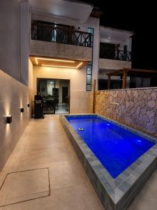 a swimming pool in the middle of a house at Casa06Frances com decoração moderna à 8min de carro da praia do frances com piscina PRIVATIVA, 03 quartos com AR in Marechal Deodoro
