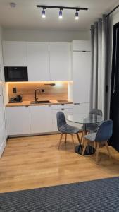 eine Küche mit einem Glastisch und zwei Stühlen in der Unterkunft ANPOL komfort in Inowrocław + 2 Fotos