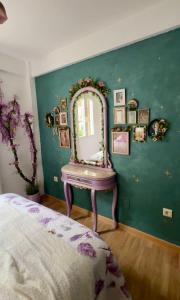 a bedroom with a mirror on a green wall at Nibelungos House - Alojamiento artesanal Whimsical frente al Pantano de San Juan - 3 min a pie in San Martín de Valdeiglesias +93 photos