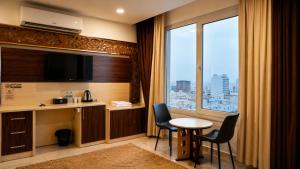 a hotel room with a table and chairs and a window at Diamond Star Hotel فندق النجمة الماسية in Seeb
