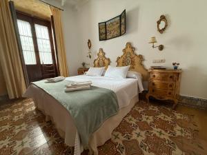a bedroom with a large bed and a dresser at Benafique La casa del Ciprés - refugio de calma en la Sierra de Huelva in Cortegana