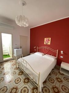 a bedroom with a large bed and a red wall at Le Nuage in Torre Lapillo