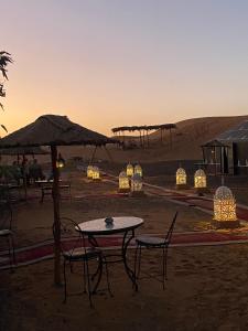 a group of tables and chairs in the desert at Merzouga Luxury Camping in Merzouga