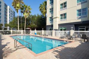 a swimming pool with chairs and a building at Fairfield Inn & Suites by Marriott Orlando International Drive/Convention Center in Orlando