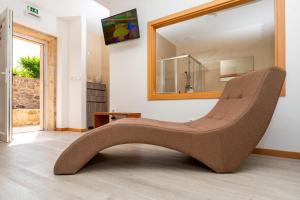 a chair in a room with a mirror at Quinta de Real in Valença