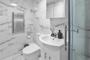 a white bathroom with a toilet and a sink at Cheshire Gold- studio apartment, Warrington in Warrington