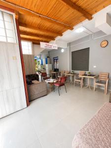 a living room with tables and chairs and a room with at Amarildo Rooms in Durrës