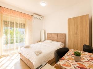 a bedroom with a large white bed and a window at Amarildo Rooms in Durrës