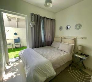 a bedroom with a bed and a large window at Beachfront Studio Flat in Cape Town