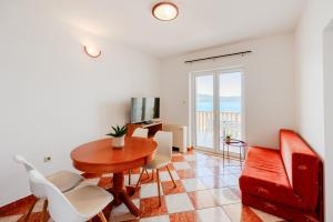 a living room with a table and chairs and a couch at Grand Holiday Residence in Komarna