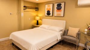 a bedroom with a white bed and a chair at Private Two Queen Beds Room Near UPEI & Downtown Cozy Retreat Near Everything in Charlottetown