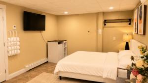 a bedroom with a bed and a flat screen tv at Private Two Queen Beds Room Near UPEI & Downtown Cozy Retreat Near Everything in Charlottetown +2 photos