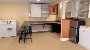a kitchen with white cabinets and a black counter top at Private Two Queen Beds Room Near UPEI & Downtown Cozy Retreat Near Everything in Charlottetown