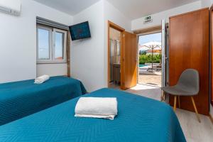 a bedroom with two beds and a tv and a chair at Quinta de Real in Valença +109 photos