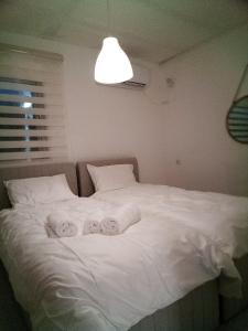 a bedroom with a white bed with towels on it at Be Netivei BE NETIVOTI in Netivot