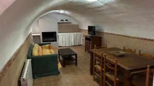 a living room with a table and a tv at Balcón de Mágina in Torres