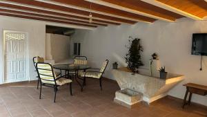 a living room with a table and chairs and a tv at Balcón de Mágina in Torres