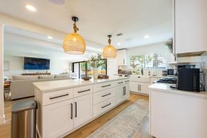 a large kitchen with white cabinets and a living room at Waterfront Paradise Dock Pool Boathouse in Jacksonville