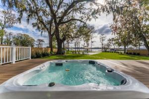 a hot tub on a deck with a tree at Waterfront Paradise Dock Pool Boathouse in Jacksonville