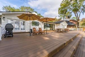 a large wooden deck with chairs and umbrellas at Waterfront Paradise Dock Pool Boathouse in Jacksonville