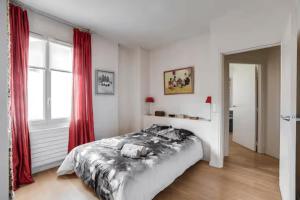 a bedroom with a large bed with red curtains at 100 m terrace parking view of the Eiffel Tower in Saint-Cloud