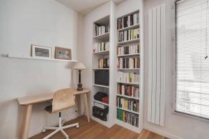 a room with a desk and a book shelf with books at 100 m terrace parking view of the Eiffel Tower in Saint-Cloud