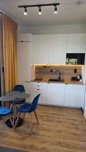 eine Küche mit einem Tisch, zwei Stühlen und einem Spülbecken in der Unterkunft ANPOL komfort in Inowrocław