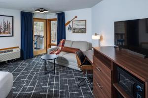 a living room with a couch and a tv at Pine Grove Resort in Ephraim