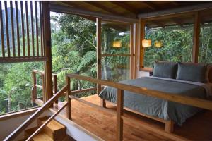 a bedroom in a tree house with a large window at MindoLoft Loft de lujo con servicio premium en Mindo in Mindo