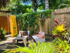 a garden with a bench and a table and a fence at Calypso cabanas in El Paredón Buena Vista