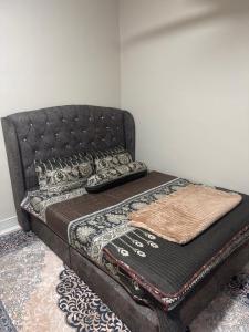 a bed with a black headboard and a pillow on it at Aariz Homestay in Malacca