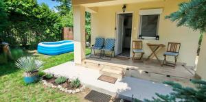 a backyard with a deck with chairs and a table at Ezüstfenyő vendégház in Balatonalmádi