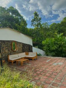 a couch sitting on a brick patio next to a building at Templo Verde Eco hostal in Minca