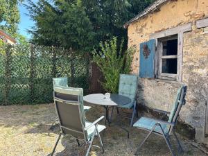 a table and chairs sitting outside of a building at Maison Le Merle Rouge in Sazeray