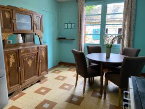 a dining room with a wooden table and chairs at Maison Le Merle Rouge in Sazeray