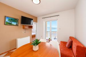 a living room with a wooden table and a couch at Royal Sea Panorama in Komarna
