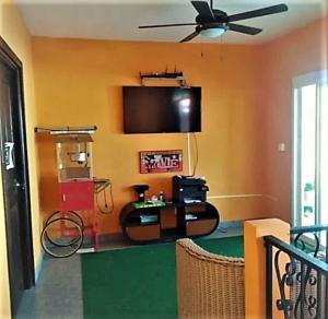 a living room with a flat screen tv and a fan at Cataleya BDT in Bocas Town