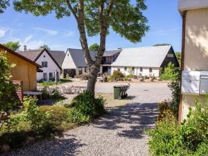 a group of houses with a tree and a street at Historic Gem in Samsø in Brundby