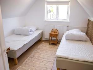 two beds in a small room with a window at Historic Gem in Samsø in Brundby