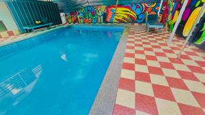 a large swimming pool with a checkered floor and a swimming pool at Harbour villa 1 in Trivandrum