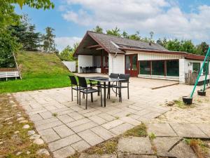 a patio with a table and chairs in front of a house at 8 person holiday home in Ebeltoft-By Traum in Ebeltoft