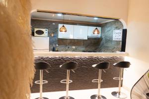 a kitchen with stools in front of a counter at Le”More House in Girardot