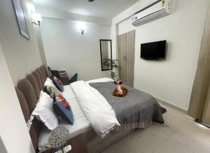 a bedroom with a bed and a tv on a wall at The Langford in Bhaktapur +7 photos