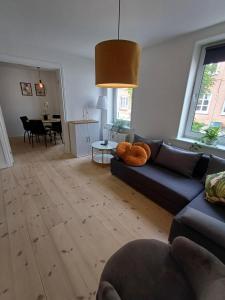 a living room with a blue couch and a table at Charming 2 bedroom apartment free parking in Hjørring