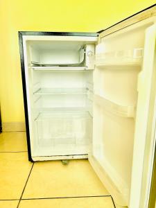 an empty refrigerator with its door open in a room at Sandel Barranca Peru in Barranca
