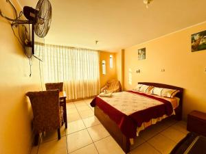 a bedroom with a bed and a table and a fan at Sandel Barranca Peru in Barranca