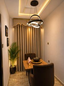 a dining room with a table and a chandelier at Restnest suite in Benin City