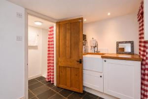a kitchen with a sink and a wooden door at Garden room, central Winchester in Winchester
