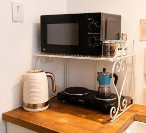 a kitchen counter with a microwave and a coffee maker at Garden room, central Winchester in Winchester