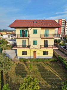 a large yellow house with a red roof at Dua 1 Apartments Shkoder in Shkodër